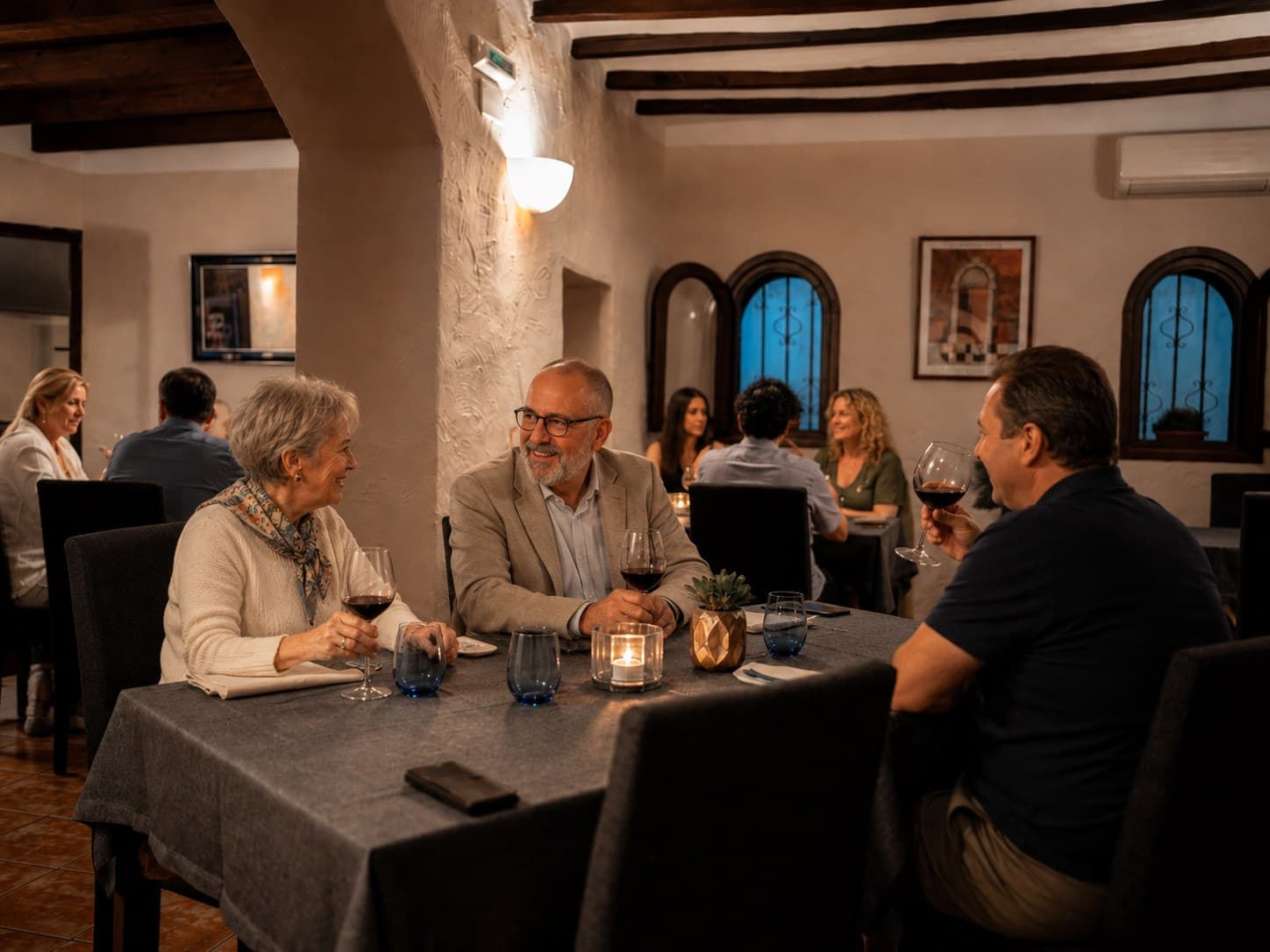 Gäste bei Wein und Gespräch an den Tischen im Gastraum