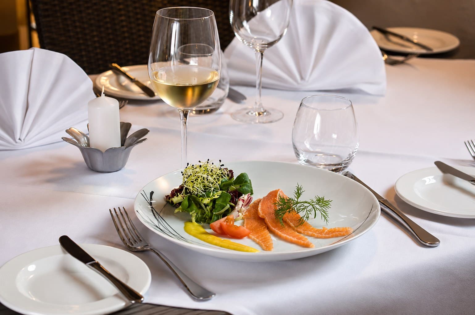 Salmón marinado con ensalada, brotes y eneldo en una mesa puesta